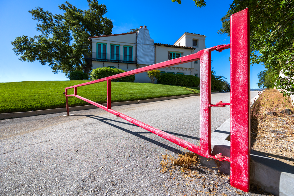 Licensed security guard checking a visitor at the entrance gatehouse of a gated townhouse community, illustrating gated community security in Surrey BC