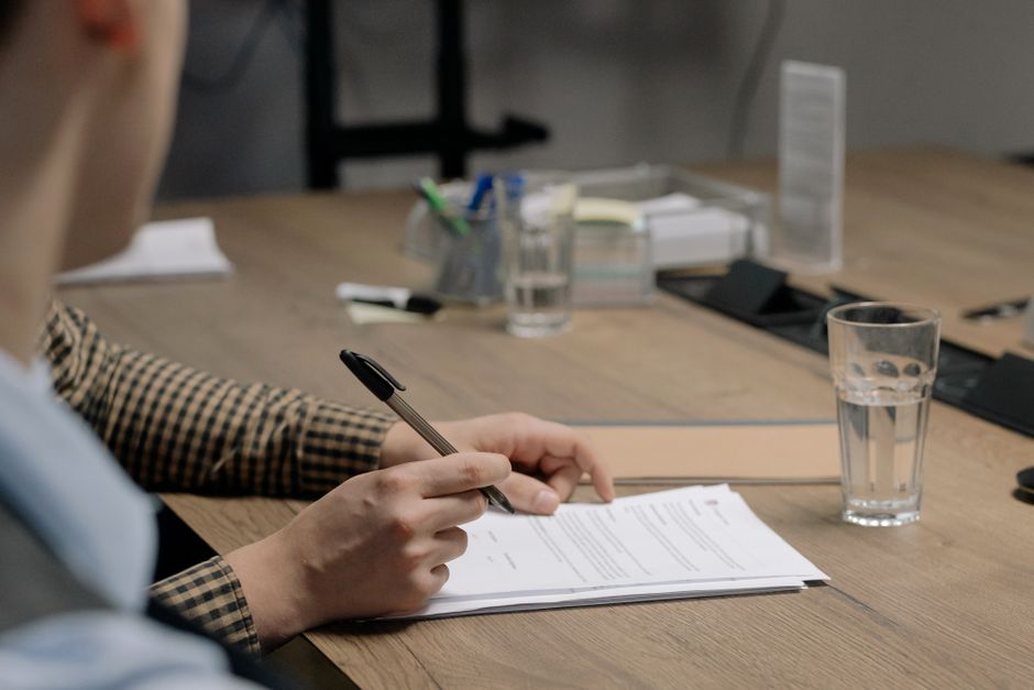 Licensed security guard reviewing a shift schedule with a property manager in a Surrey office, illustrating security guard cost planning in BC