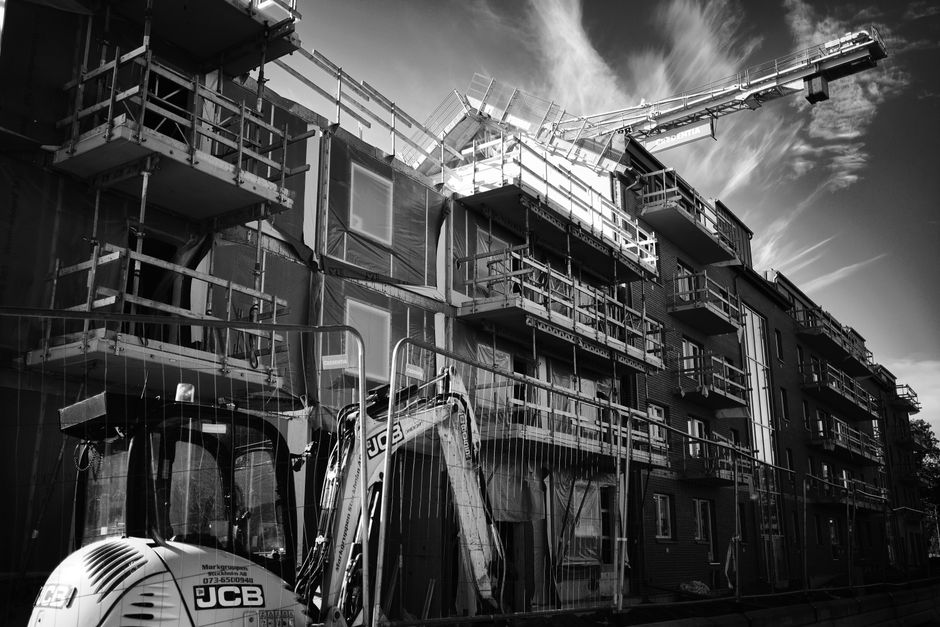 Security guard checking the gate of a fenced construction site in Surrey BC at dusk